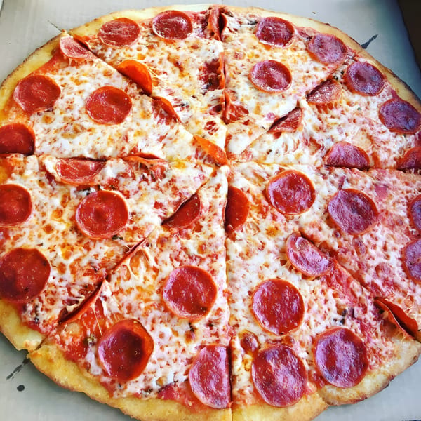 A whole All Star Pizza Bar pepperoni pizza, cut into slices, in a delivery box.