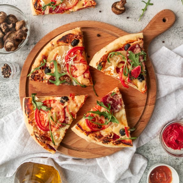Four slices of All Star Pizza Bar pizza with various toppings on a wooden board.